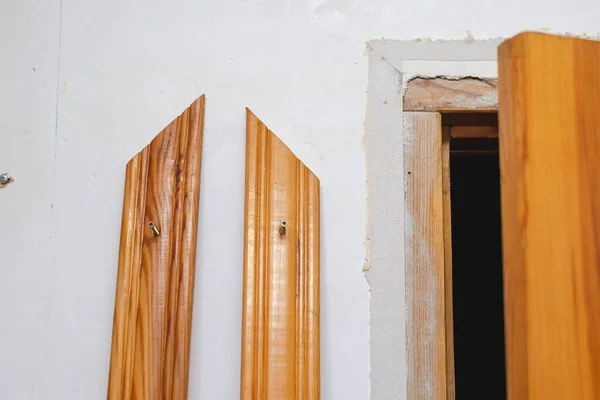 Montaż wykończenia drzwi w pomieszczeniu. Drzwi drewniane i dwa de — Zdjęcie stockowe