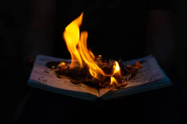 Открытый горящий дневник на черном фоне. Ноутбук с огненной бухтой — стоковое фото