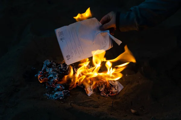 Uma mulher atira as páginas de um diário de negócios para um incêndio. Burnina — Fotografia de Stock