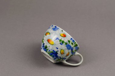 Gri arka planda seramik çay fincanı olan minimalist kompozisyon. B