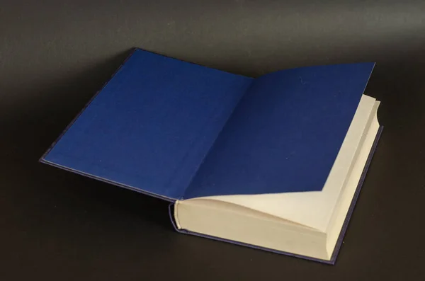 Open boek op een zwarte achtergrond. Handboek met blauwe eindpapieren. H — Stockfoto