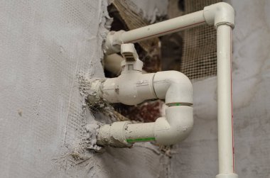 Gri duvardaki plastik borular. Kapı valfleri ile borular. Uzak