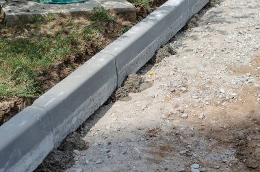 Yeni kaldırımlar kuruluyor. Gri kaldırımlar betona sabitlenmiş.