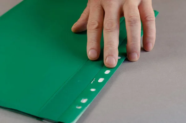 Ώριμο αρσενικό χέρι βρίσκεται στην κορυφή του πράσινου φακέλου αρχείων. Τύπος προσώπου — Φωτογραφία Αρχείου