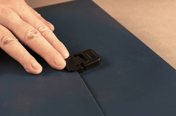 Мужчина открывает ящик с голубым портфелем для бумаг. Закрытый гибкий бри