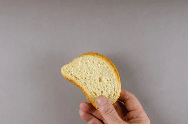 Una mano sostiene una rebanada de pan de trigo. Un hombre adulto y una rebanada de — Foto de Stock