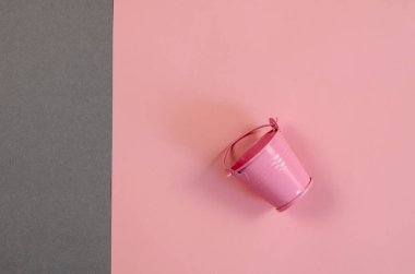 Gri-pembe üzerinde çocuk oyuncak kovası olan minimalist kompozisyon