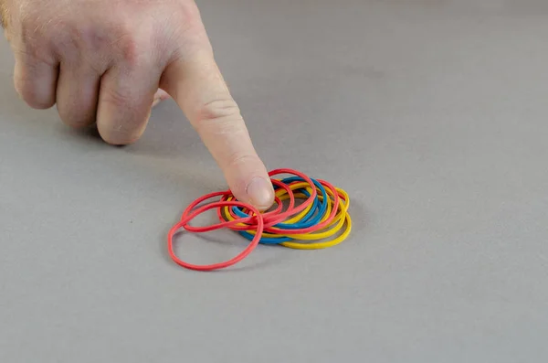 De wijsvinger wijst naar de elastiekjes. Groepen van multicolo — Stockfoto