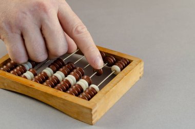 Yetişkin bir erkek tahtadan abaküs üzerinde hesaplamalar yapar. Erkekler...