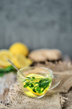 Limonlu sıcak çay, zencefil ve nane. Soğuk algınlığına karşı zencefilli çay ve bağışıklık sistemini güçlendirmek. Kopyalama alanı ve dikey çerçeve ile yakın plan