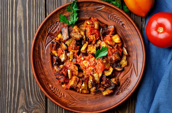Domates soslu ızgara Türk patlıcan (soslu patlıcan veya saksuka). Lezzetli ve basit bir Türk yemeği ya da ana yemek için aperatif. Koyu ahşap üzerine yerleşim