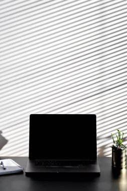 Bilgisayarlı ev bilgisayarı, minimal stil. Karantina sırasında ev ofisi, duvarda parlak güneş ışığı, kontrastlı fotoğraf, kopyalama alanı