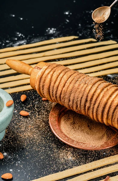 Trdelnik pişiriyorum. Şişte pişmiş lezzet ve şeker, tarçın ve vanilyalı kömür hamuru. Noel tatlıları, sokak yemekleri. Çek ve Moravya mutfağı.