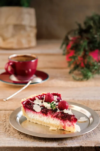 Cherry pie with ricotta and almond flakes, selective focus on cherries. Close-up, breakfast in a cafe, cup with espresso on the background
