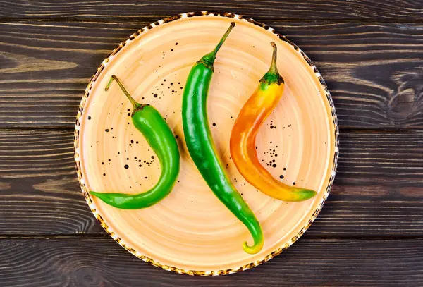 Spicy green and red peppers on a platter. Spanish tapas on wooden vintage background. Flat top view, food still life concept — Stock Image Spicy Green Red Peppers Platter Spanish Tapas Wooden Vintage Background Royalty Free Stock Photos