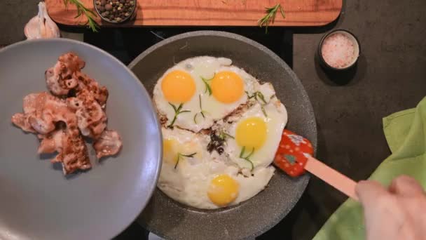 ベーコンと目玉焼き スパイスとフライパンでローズマリー 上から見た目玉焼き 朝食またはケトの食事のアイデア — ストック動画