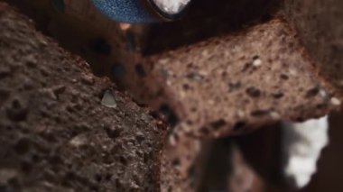 Masada kamera hareketi, taze pişmiş geleneksel çavdar ekmeği ve tohumlu ekşi ekmek. Masada yaprak ve un var. Yakın plan Seçici odak, sığ alan derinliği