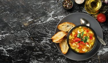 Siyah bir tabakta, siyah bir masada sebze çorbası, üst manzara. Mevsimlik sebzeli İtalyan çorbası. Lezzetli vejetaryen yemek konsepti. Metin için kopyalama alanı olan düz uzandı