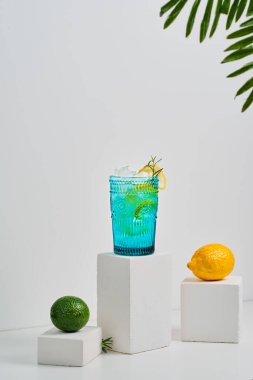 Buzlu su, taze limon ve limon meyvelerinden yapılmış sağlıklı bir içecek. Açık gri arka planda, seçici odak noktasında minimalist ve soyut bir hayat. Doğal ev yapımı içecek.