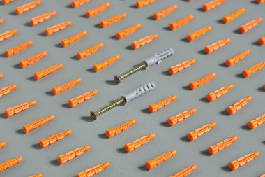 Plastik kaplamaları kırmızıya yakın plan, tarafsız gri arka plan. Duvar dayanakları, pankart ya da arka plan fikri, seçici odaklanma. Parlak güneş ışığı