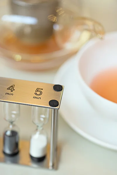 Tea cup with sand watch — Stock Photo, Image