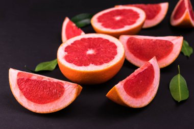 Gri meyveler siyah arka planda takozlara ayrılır..