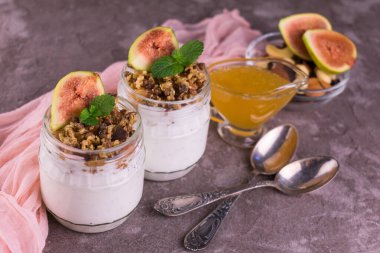 Gri arka planda taze incirli iki yoğurt..