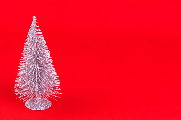 Kleine Glimmende Kerstboom Een Rode Achtergrond Kopieerruimte — Stockfoto
