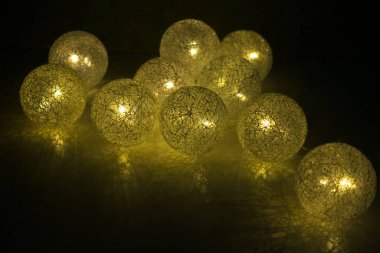 Sarı fenerler karanlıkta yanar. Parlayan Noel topları.