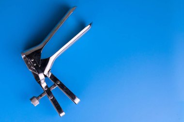 Açık mavi arka planda jinekolojik spekulum. Uzayı kopyala Jinekolojik inceleme aracı.