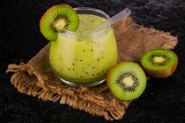 Siyah arka planda bir bardakta kivi kokteyli. Sağlıklı bir vitamin içeceği.