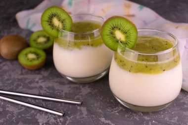 İki bardak sağlıklı kivi ve bir dilim kivi ile birlikte yoğurt püresi. Yakın plan..