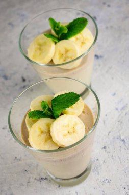 Beyaz arka planda dilimlenmiş muzlu krema..