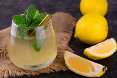 Siyah arka planda naneli bir bardak limon suyu. Yakın plan..