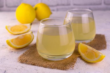 Beyaz arka planda iki bardak taze sıkılmış limon suyu..
