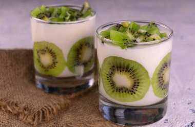 Kivili tatlı ve beyaz tabakta yoğurt..