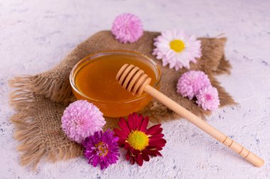 Beyaz arka planda çiçekli bir kase bal..