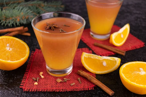 Portakal suyu ve baharatlı sıcak şarap siyah arka planda yeni yıl kompozisyonu ile süslenmiş..