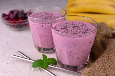 Beyaz arka planda chia tohumlu iki bardak muzlu smoothie..