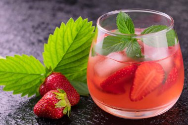 Siyah arka planda buzlu ve naneli çilekli içecek. Yakın plan..