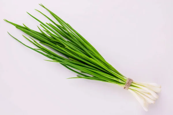 Beyaz arka planda bir sürü yeşil soğan. Düz yatıyordu.