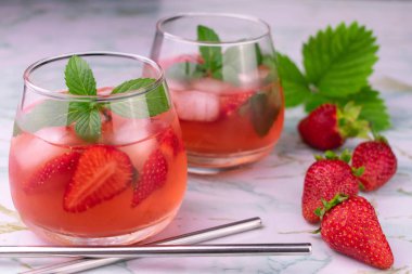 Mermer arka planda iki bardak çilekli nane likörü. Yakın plan..