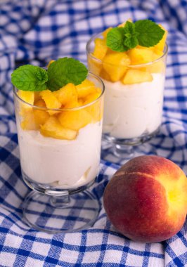 Yogurt with fresh peach and mint leaf. View from above.