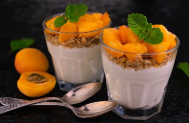 Kayısı yoğurdu ve siyah arka planda granola. Yakın plan..