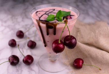 Çikolata damlayan uzun bir bardakta vişneli buzlu içecek. Yakın plan..