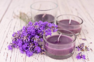 Beyaz ahşap arka planda lavanta kokulu mumlar..
