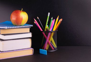 Okul konseptine geri dönelim. Elma, kitaplar ve okul malzemeleri kara tahta üzerine boyanmış. Boşluğu kopyala.