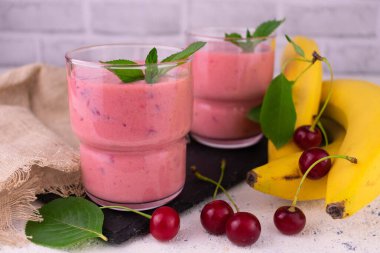 Muz ve nane yaprağıyla süslenmiş taze vişne suyu..