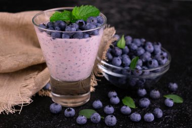 Siyah arka planda bir bardak sağlıklı yaban mersini suyu. Yakın plan..