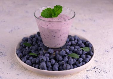 Böğürtlen suyu ve beyaz arka planda bir sürü taze yaban mersini..